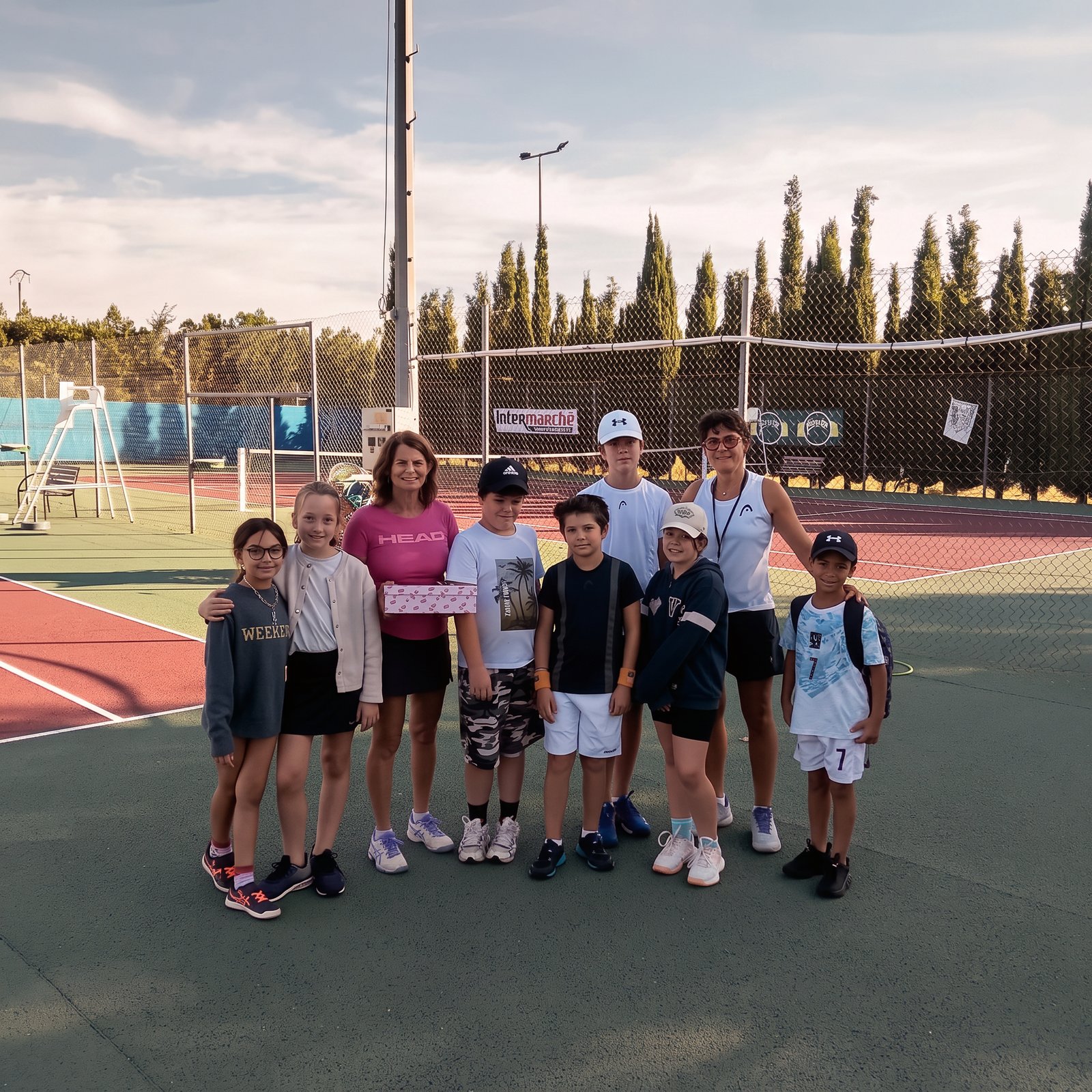 Groupe d'enfants et encadrantes sur le court du Tennis Club d'Uchaud, août 2026