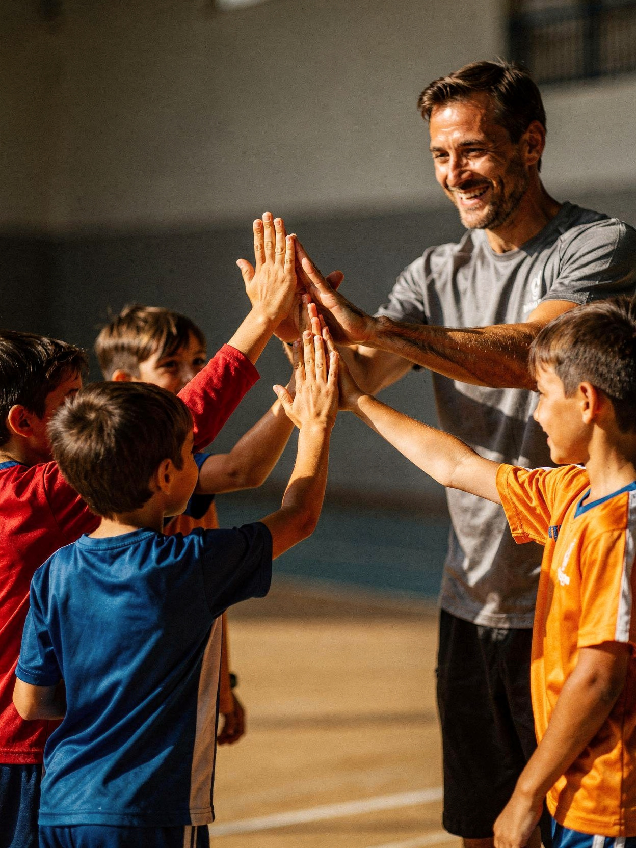 Éducateur et enfants réalisant un high-five collectif